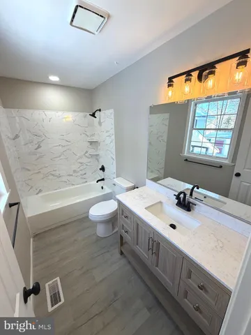 a bathroom with a double vanity sink toilet and shower