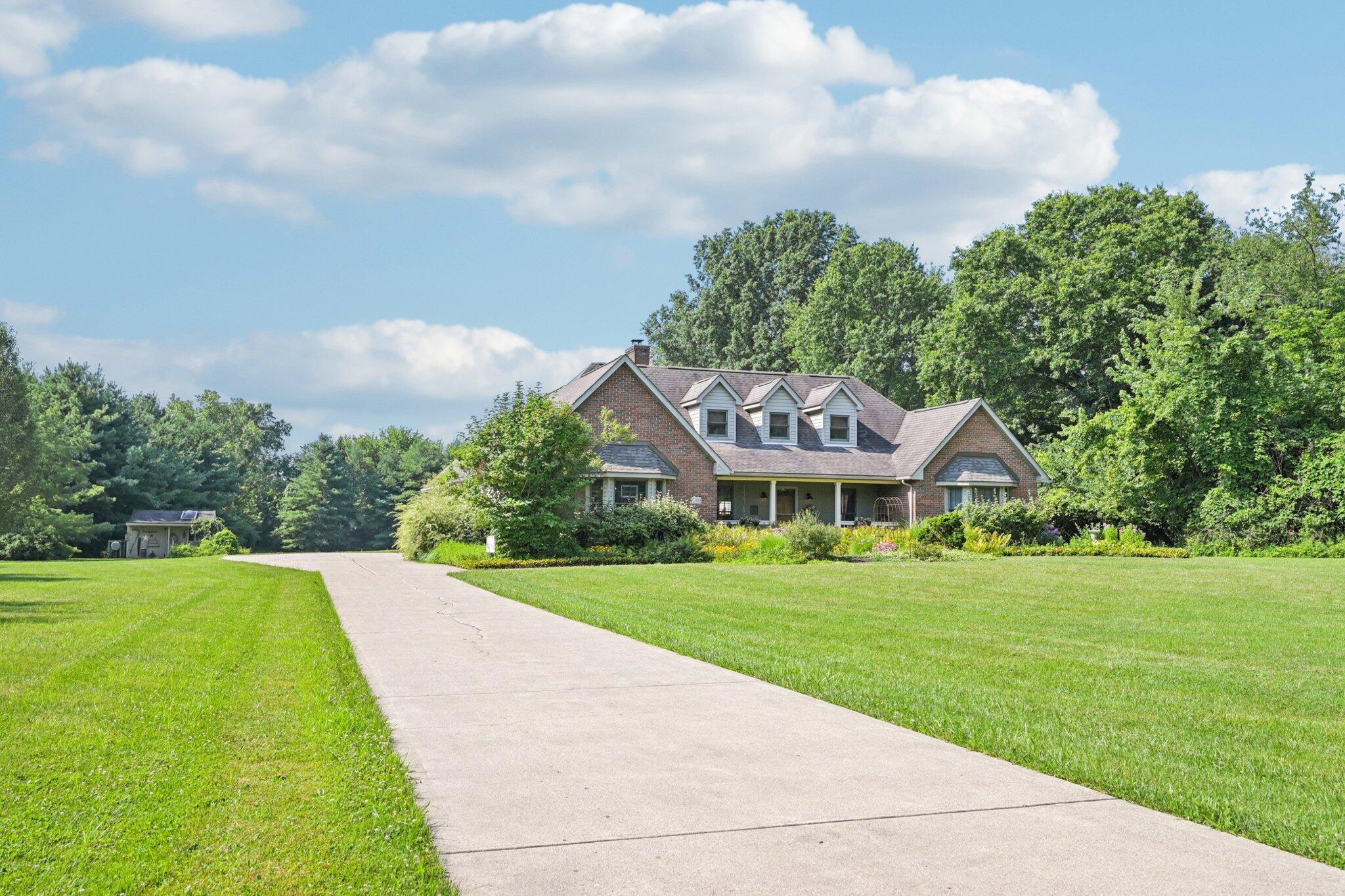 7700 Plumb Road Galena, OH 43021 - Photo 89 of 94 Wide concrete drive leads to a custom-built brick Cape Cod, nestled on a beautifully landscaped and private lot surrounded by mature trees.