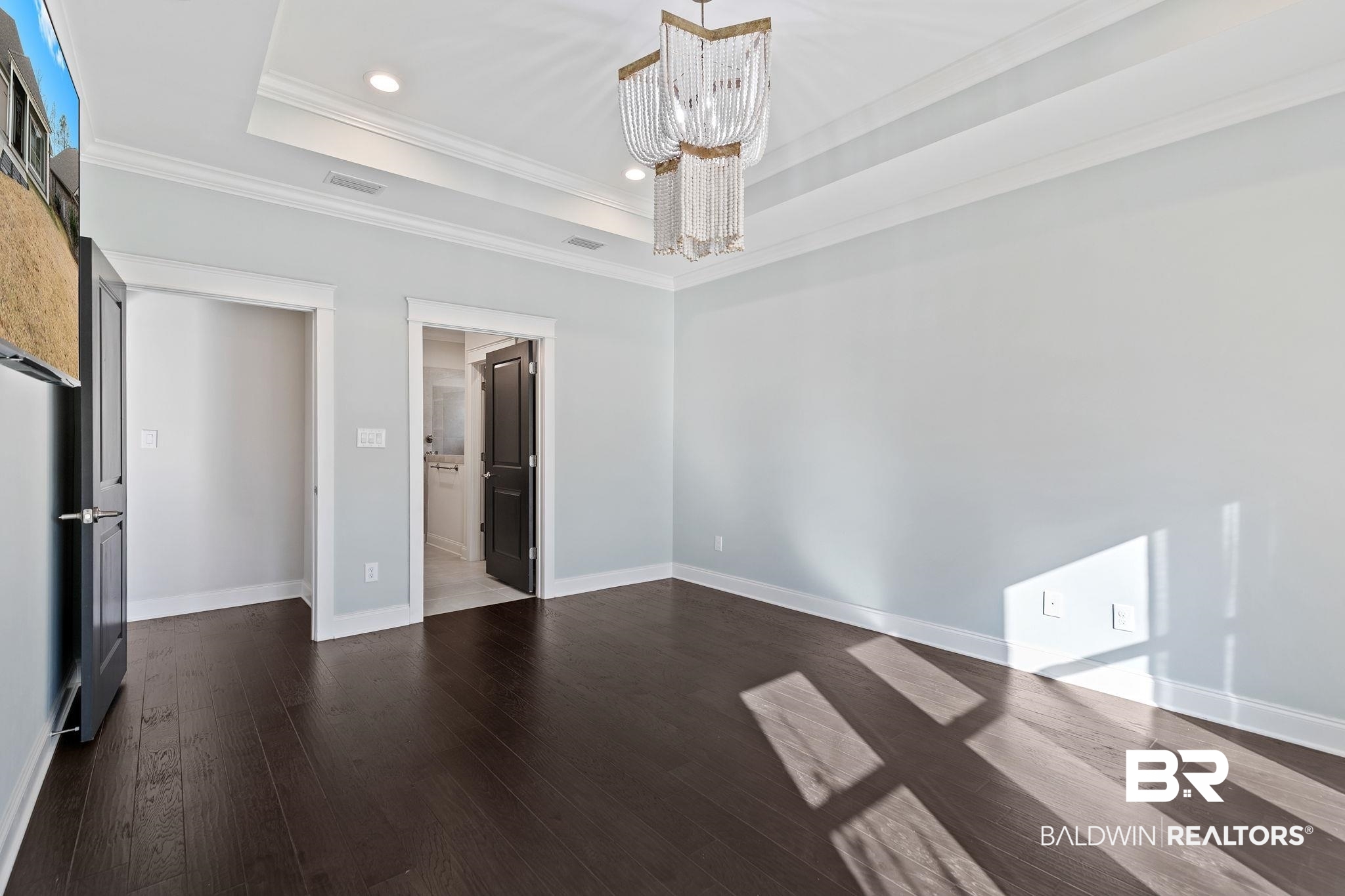 31654 Canopy Loop Daphne, AL 36527 - Photo 31 of 64 Unfurnished bedroom featuring crown molding, dark wood finished floors, a chandelier, ensuite bathroom, and a tray ceiling