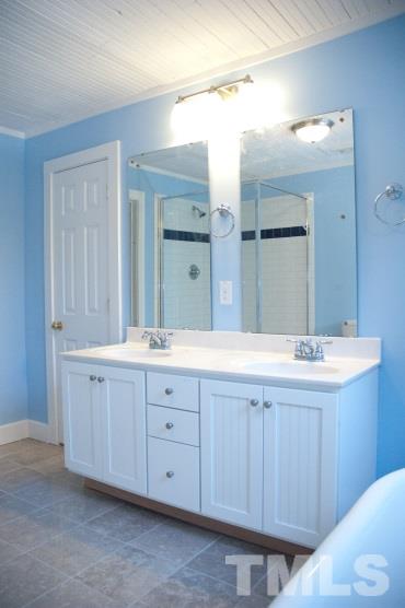 112 Camden Street Raleigh, NC 27601 - Photo 8 of 25 a bathroom with a granite countertop sink and a mirror