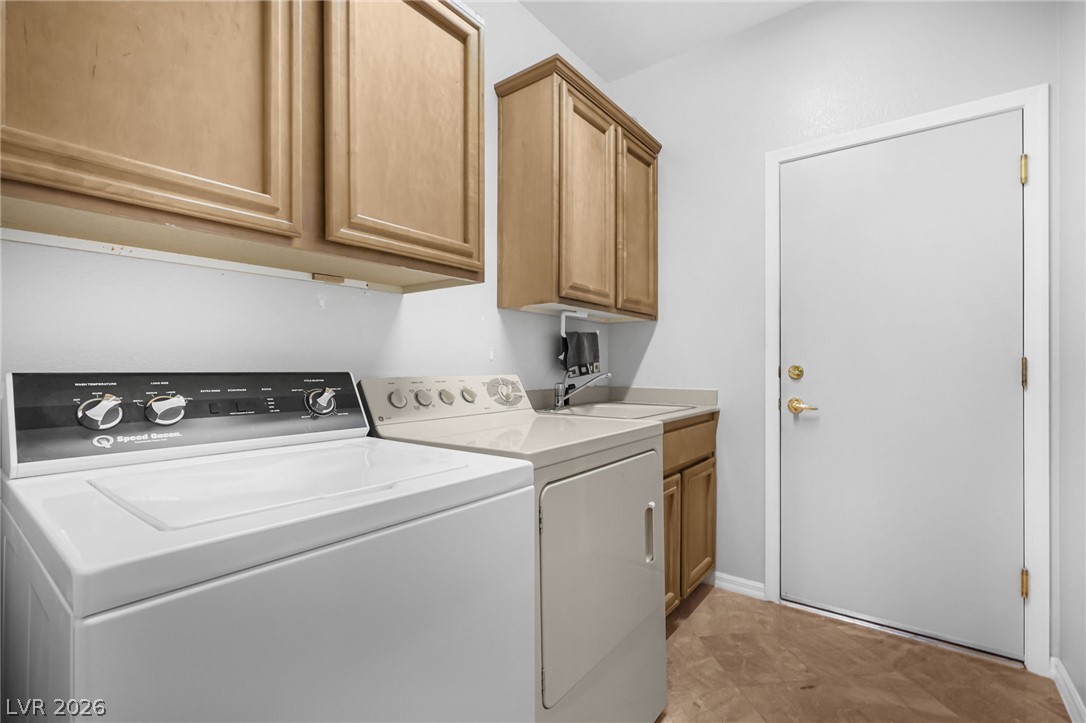 2738 Grand Forks Road Henderson, NV 89052 - Photo 30 of 52 A functional laundry area includes built-in cabinetry and durable tiled flooring.