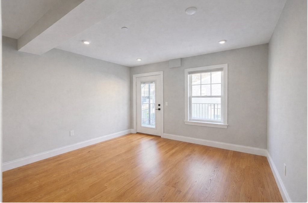 33 Boardman Street, Unit 2 Boston, MA 02128 - Photo 6 of 11 an empty room with wooden floor and windows