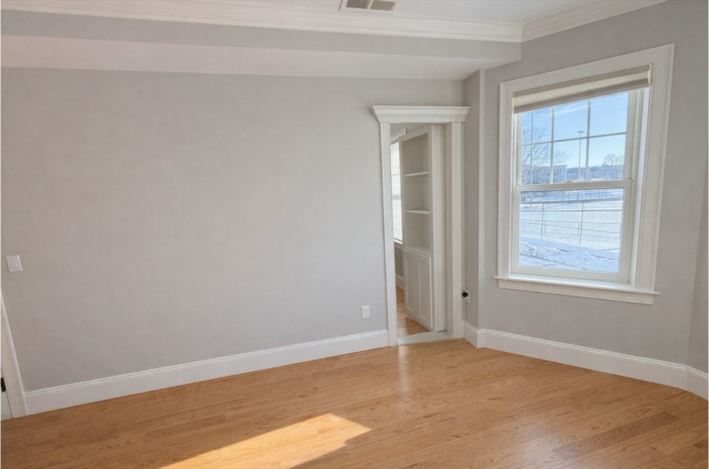33 Boardman Street, Unit 2 Boston, MA 02128 - Photo 8 of 11 an empty room with wooden floor and windows