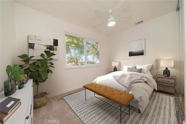a bedroom with bed and a potted plant