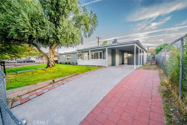 a front view of a house with a yard and potted plants