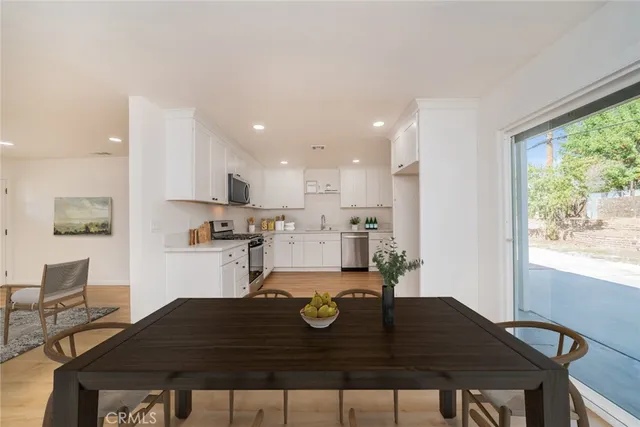 a kitchen with a table chairs and wooden floor