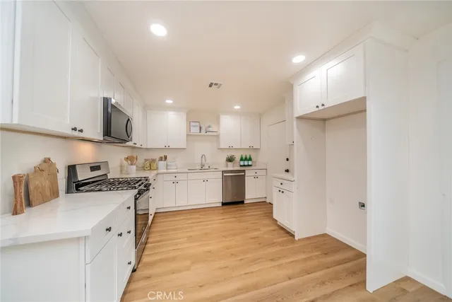 a kitchen with white cabinets and white appliances