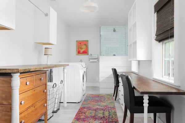 a kitchen with stainless steel appliances granite countertop a table chairs in it and wooden floors