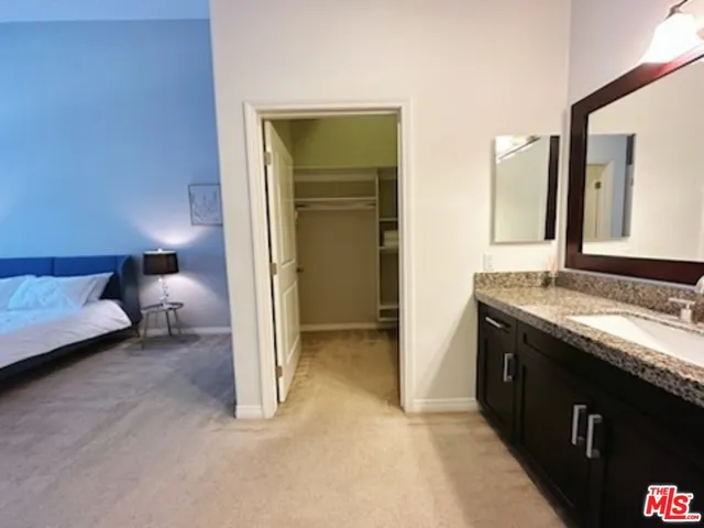 a spacious bathroom with a granite countertop sink and a mirror