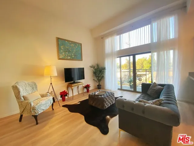 a living room with furniture wooden floor and a flat screen tv