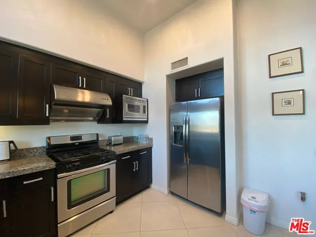 a kitchen with stainless steel appliances a stove a microwave and a refrigerator