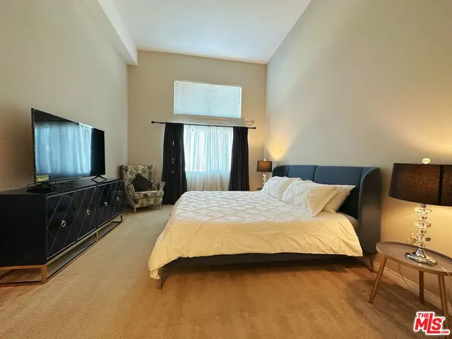 a bedroom with a bed and a flat screen tv