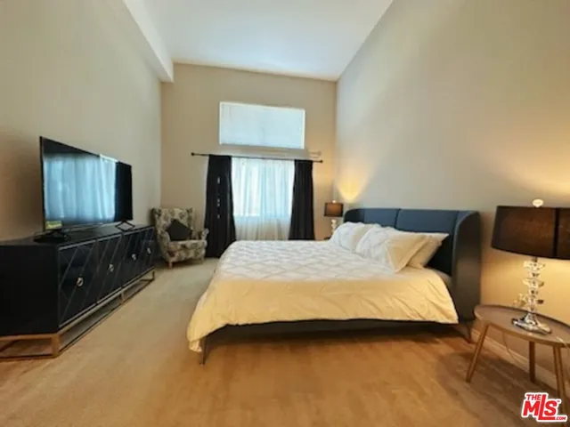 a bedroom with a bed and a flat screen tv