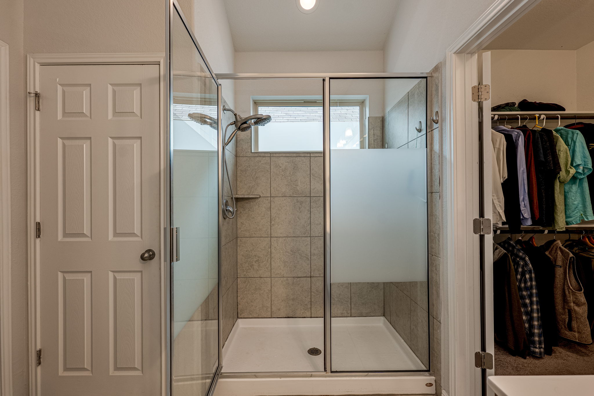1009 Goldilocks Lane Manchaca, TX 78652 - Photo 22 of 40 Glass-enclosed shower with a tiled surround, integrated shelf, and frosted privacy panel.