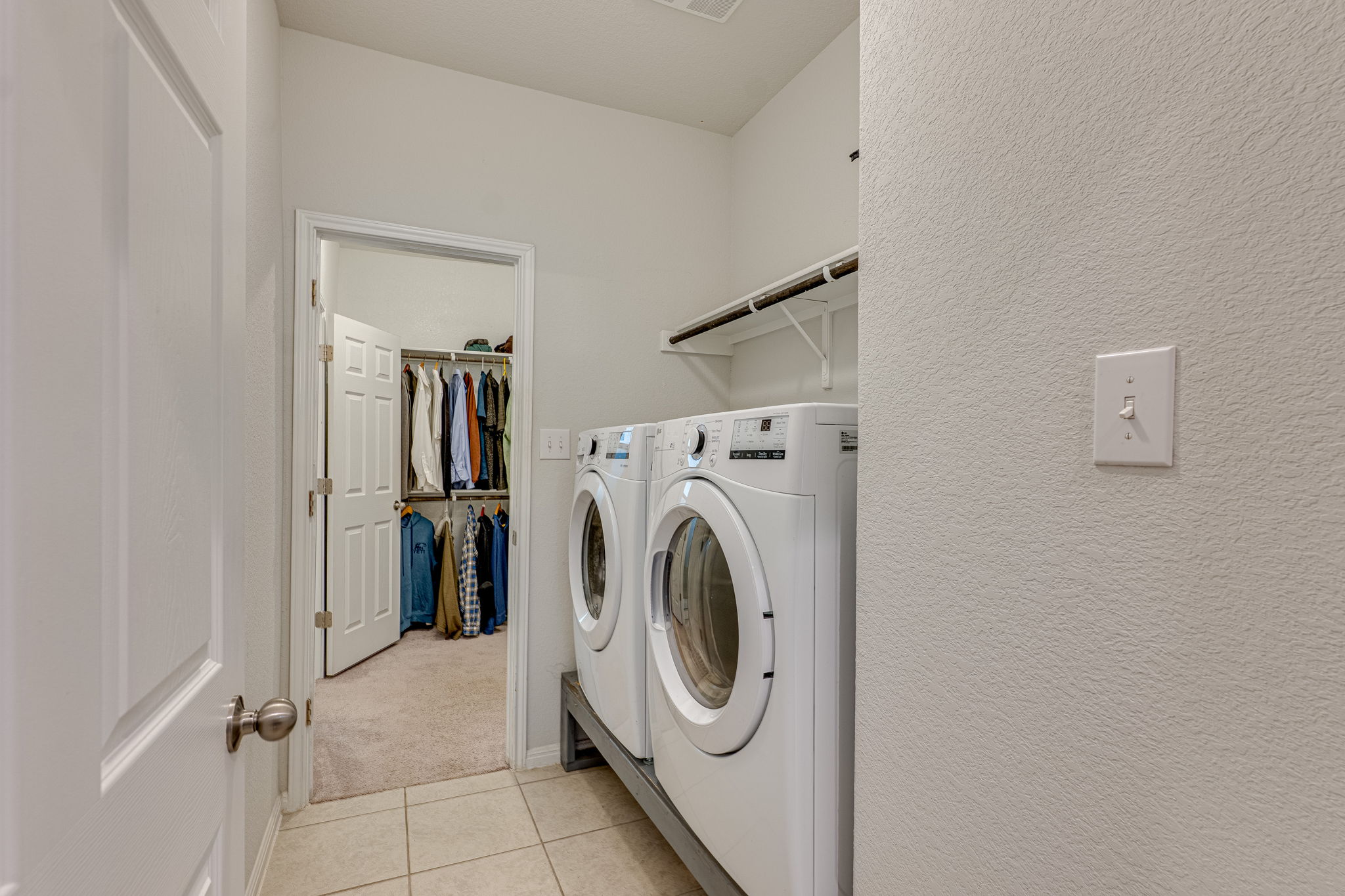 1009 Goldilocks Lane Manchaca, TX 78652 - Photo 25 of 40 Laundry area featuring ceramic tile flooring, built-in shelving, and direct access to the second walk-in closet for the primary suite.