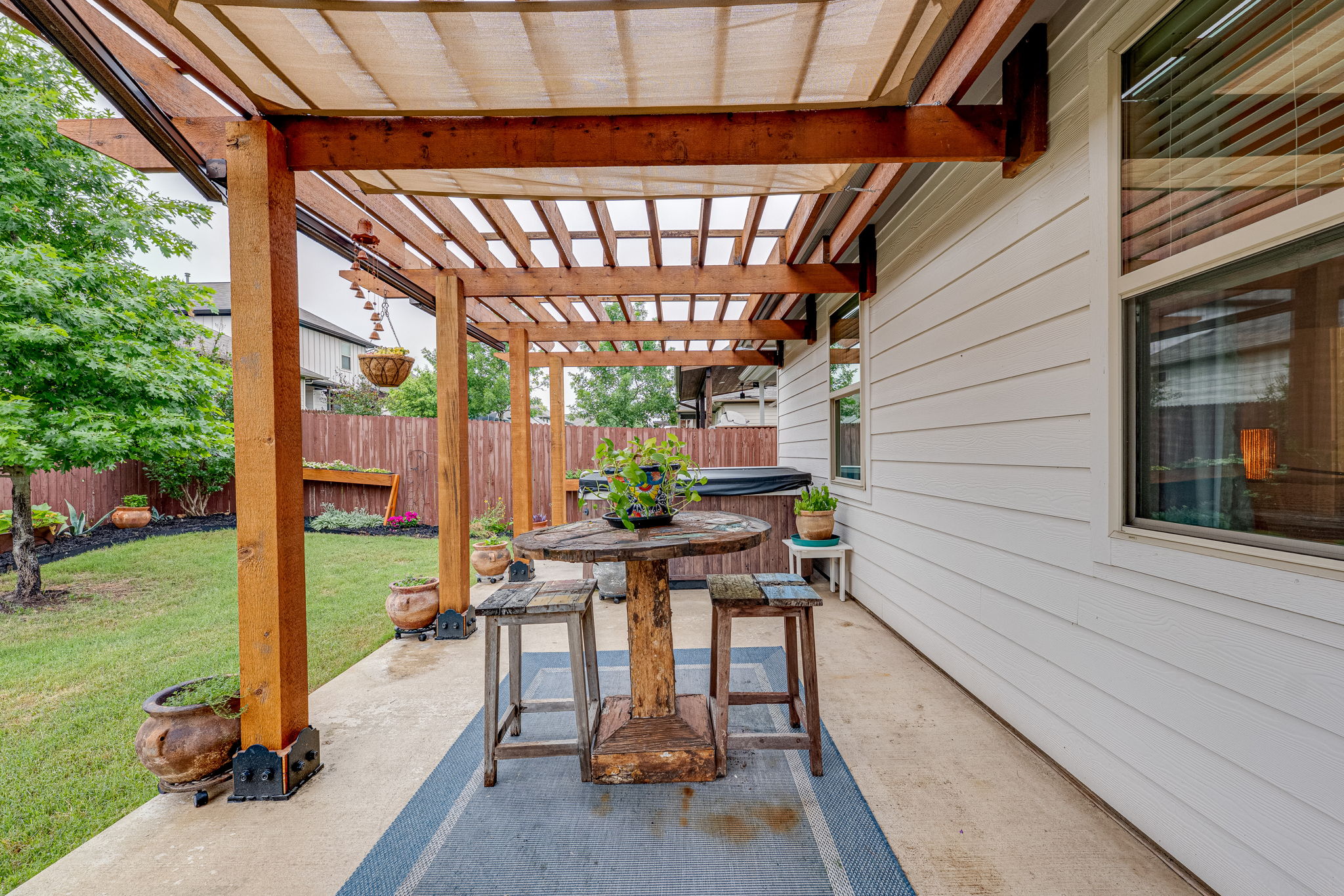 1009 Goldilocks Lane Manchaca, TX 78652 - Photo 34 of 40 Concrete patio featuring a wood pergola with a translucent fabric canopy.