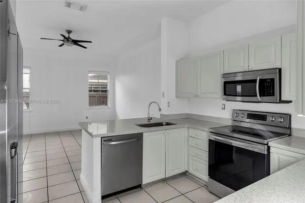 a kitchen with stainless steel appliances granite countertop a sink a stove and a refrigerator