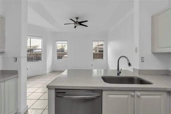a kitchen with white cabinets a sink and a stove with wooden floor
