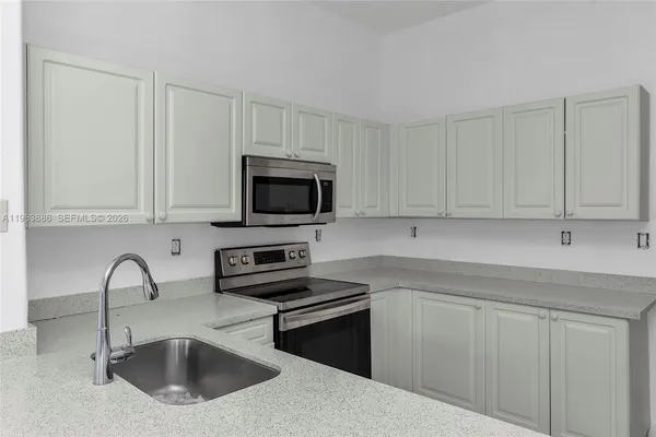 a view of kitchen with refrigerator and cabinets