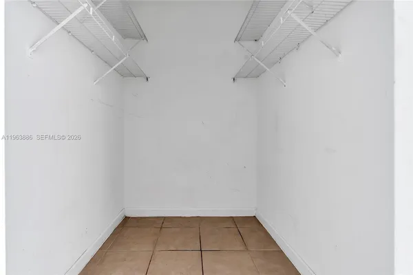 a view of a balcony with a floor to ceiling window and potted plants