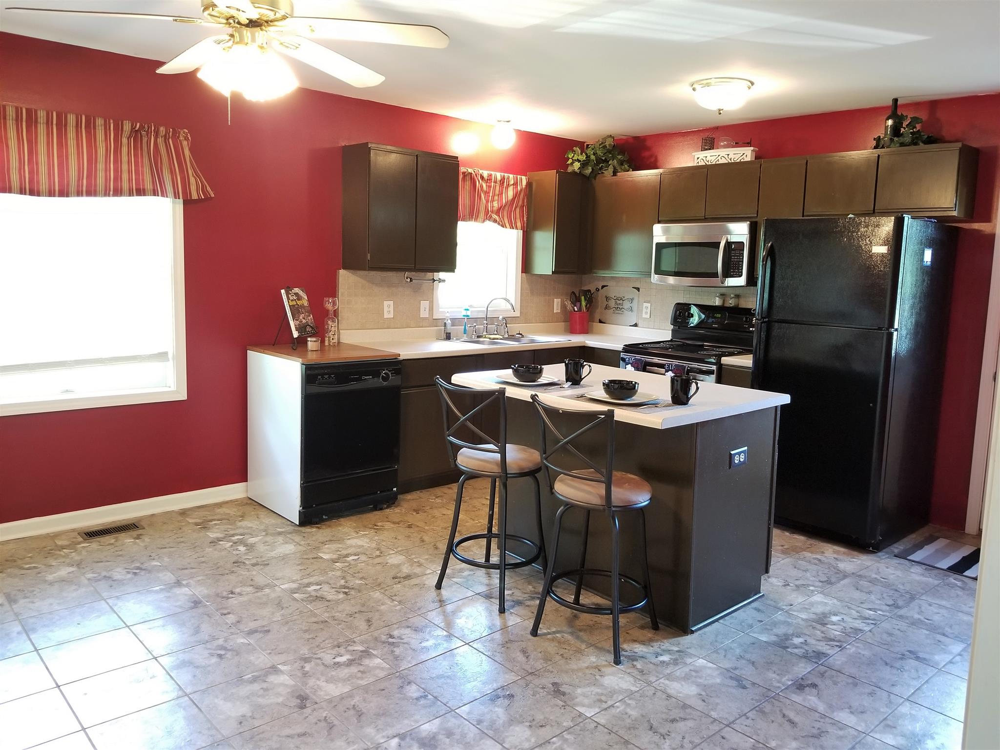 3312 Friendship Road Cross Plains, TN 37049 - Photo 6 of 11 a kitchen with stainless steel appliances a sink a stove a refrigerator cabinets and a dining table