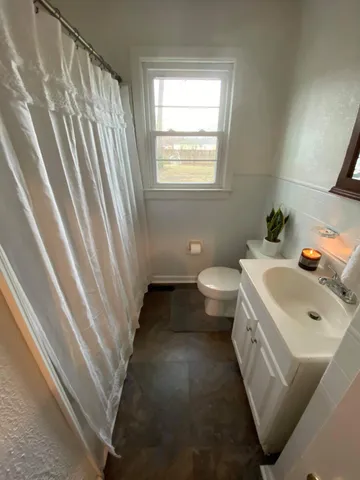 a bathroom with a sink toilet and window