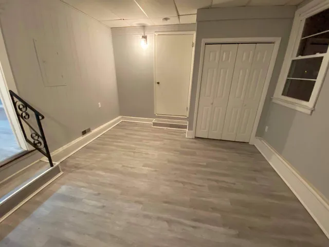 a view of a room with wooden floor and white walls