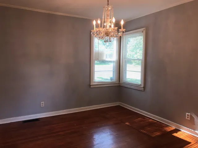 a view of a room with wooden floor and chandelier