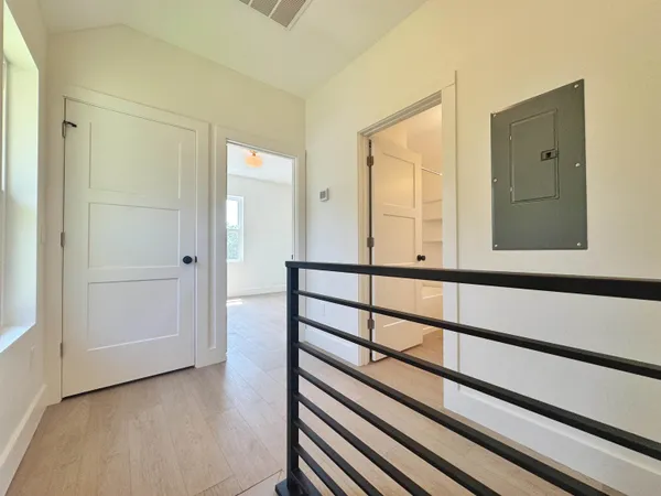 a view of a hallway with wooden floor and a window