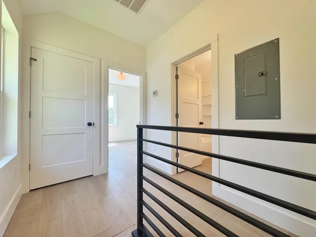 a view of a hallway with wooden floor and a window