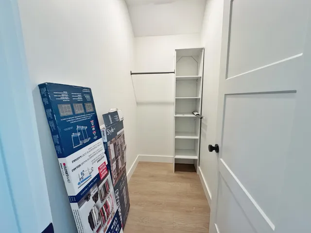a view of walk in closet with clothes and shoes
