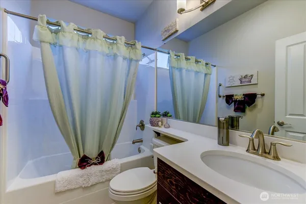 a bathroom with a sink a toilet a tub and shower