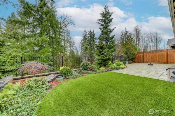 a view of backyard with swimming pool and green space