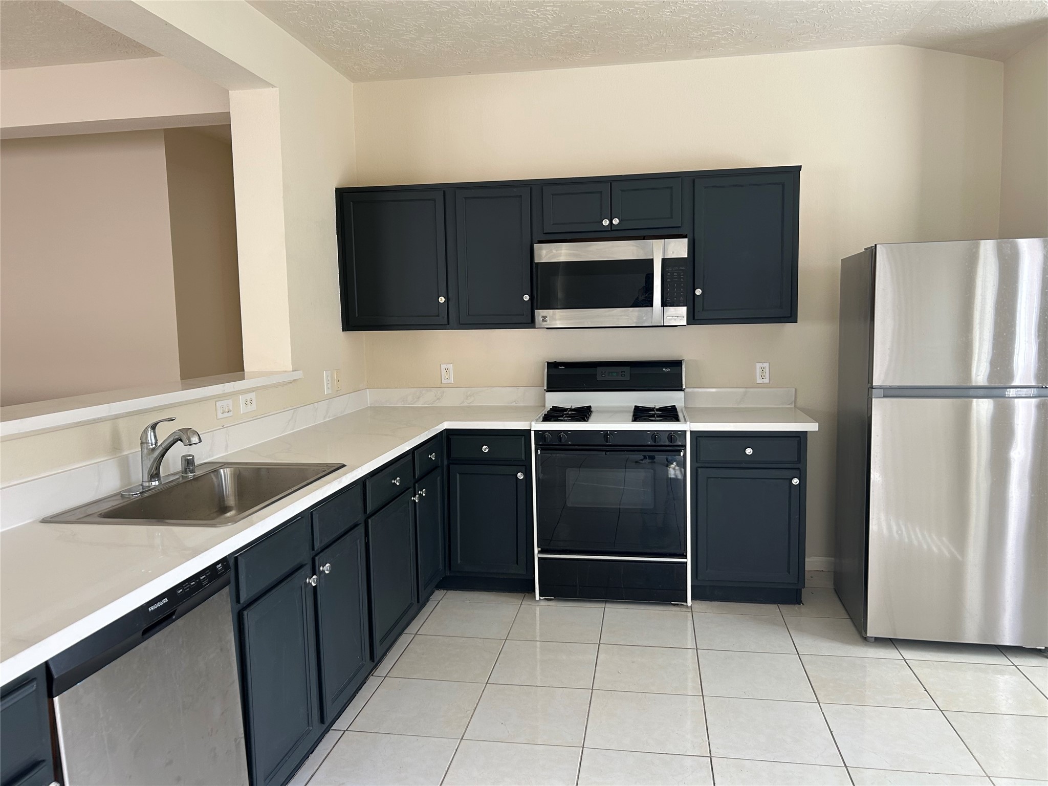 11635 Alpine Vale Court Houston, TX 77038 - Photo 7 of 18 a kitchen with a refrigerator and a sink