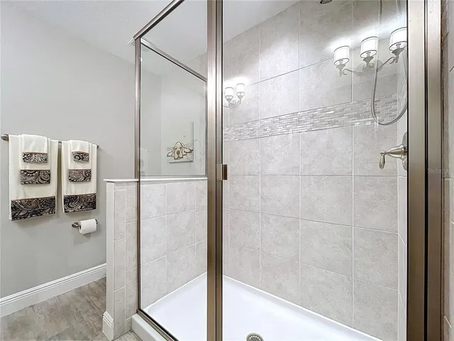 a bathroom with a glass shower door and a mirror