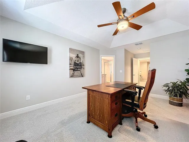 a view of a workspace with furniture and a window