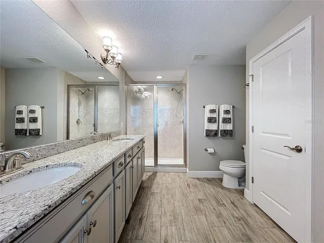 a spacious bathroom with a granite countertop sink toilet and shower