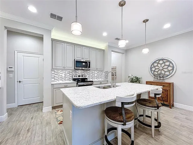 a kitchen with a dining table chairs refrigerator and cabinets