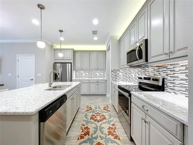 a kitchen with stainless steel appliances granite countertop a sink stove and microwave