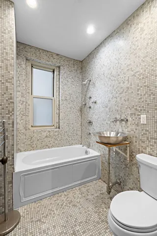 a bathroom with a toilet a sink and bathtub