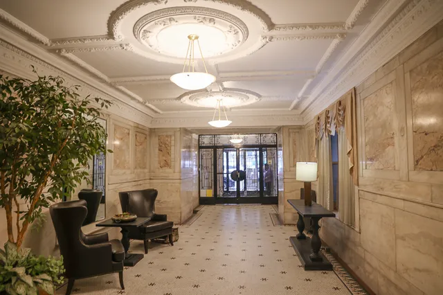 a living room with furniture a fireplace and a chandelier