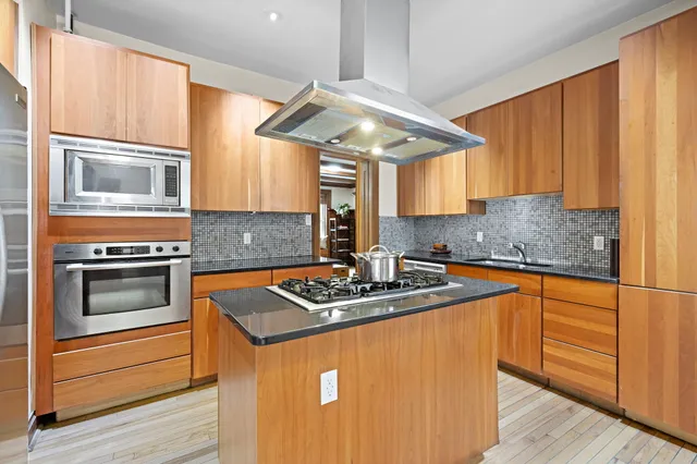 a kitchen with stainless steel appliances granite countertop a sink stove and cabinets