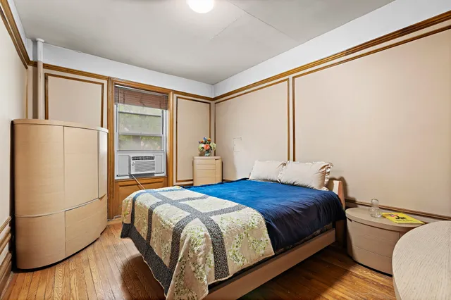 a bedroom with a bed and a refrigerator