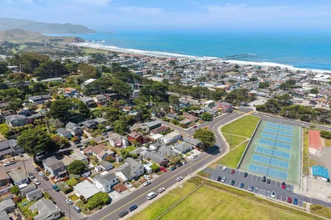 an aerial view of a residential houses with city view