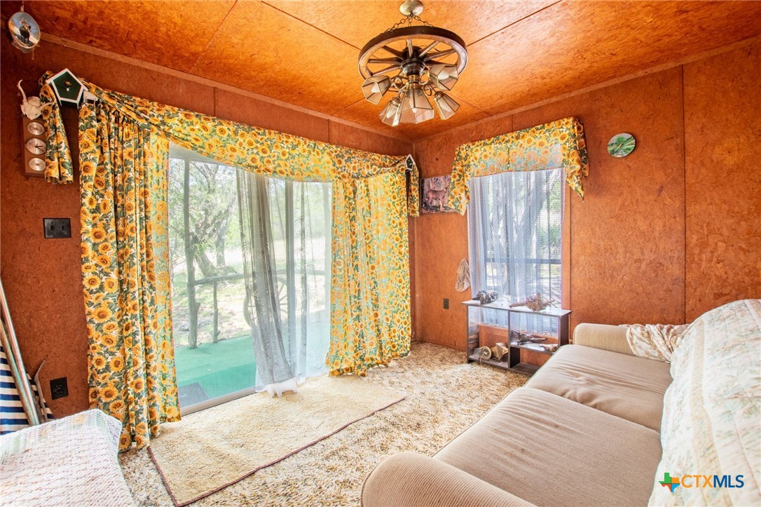 322 Cliff View Road Lampasas, TX 76550 - Photo 15 of 33 a bedroom with a bed and a chandelier