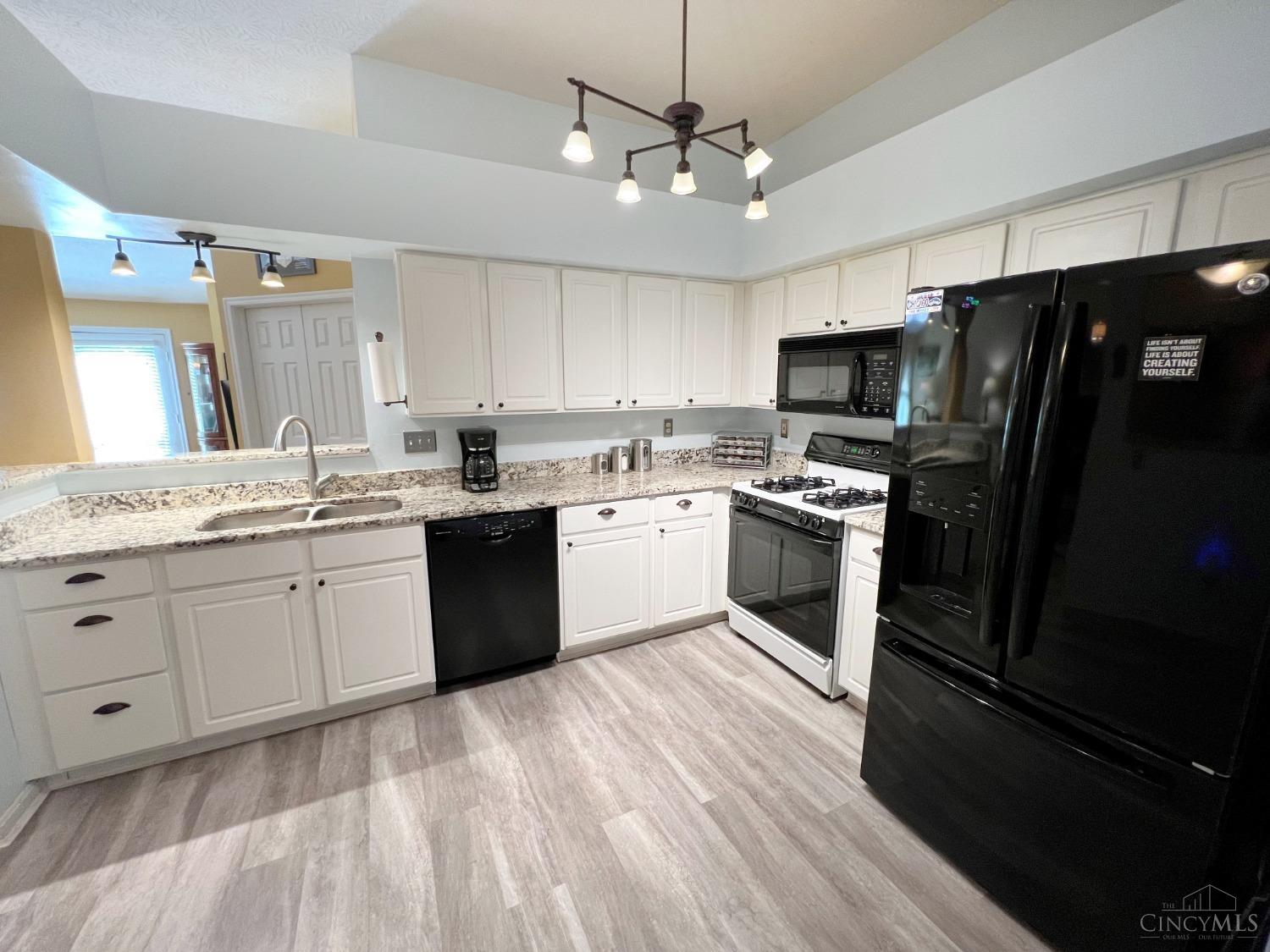 8408 Ridge Pointe Court, Unit 13 Reading, OH 45237 - Photo 7 of 39 Here's a view of the kitchen with granite counters, stylish lighting, laminate flooring, all appliances included: refrigerator, gas stove, dishwasher, microwave and garbage disposal.
