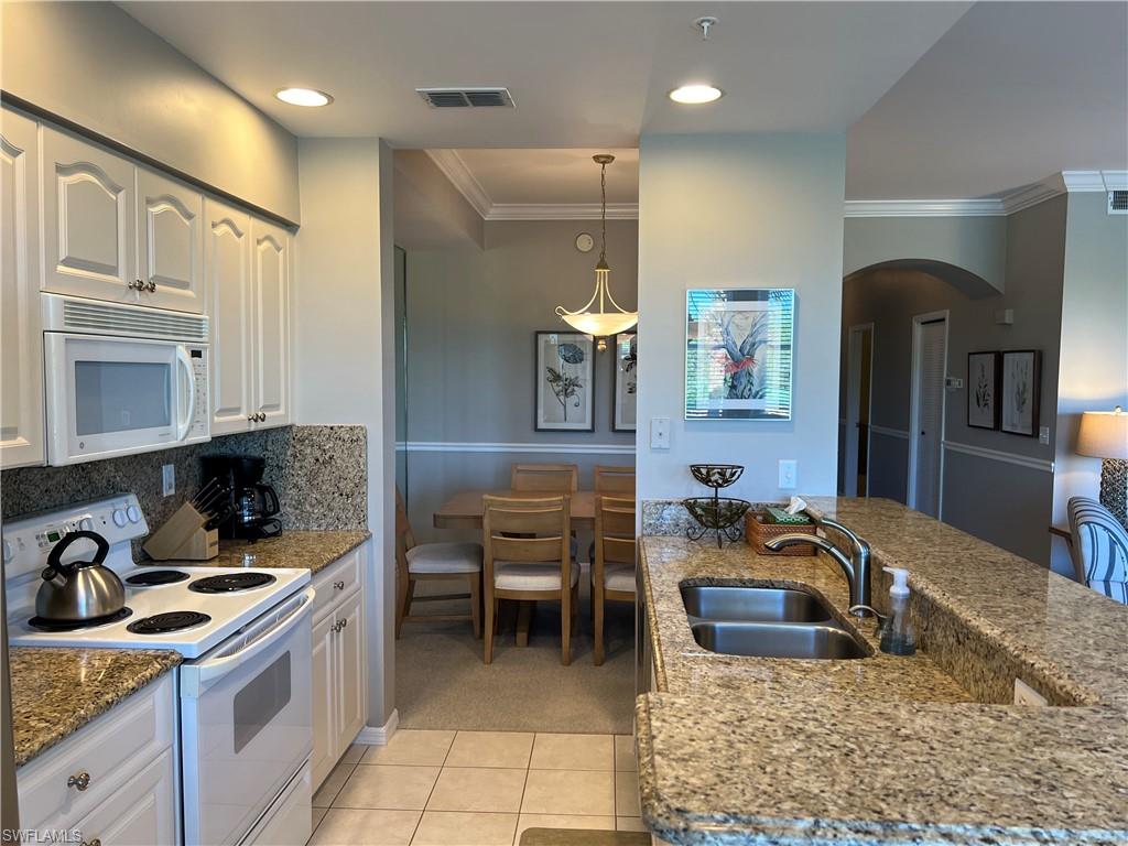 7625 Arbor Lake Court, Unit 332 Naples, FL 34112 - Photo 11 of 26 a kitchen with stainless steel appliances granite countertop a sink and a refrigerator