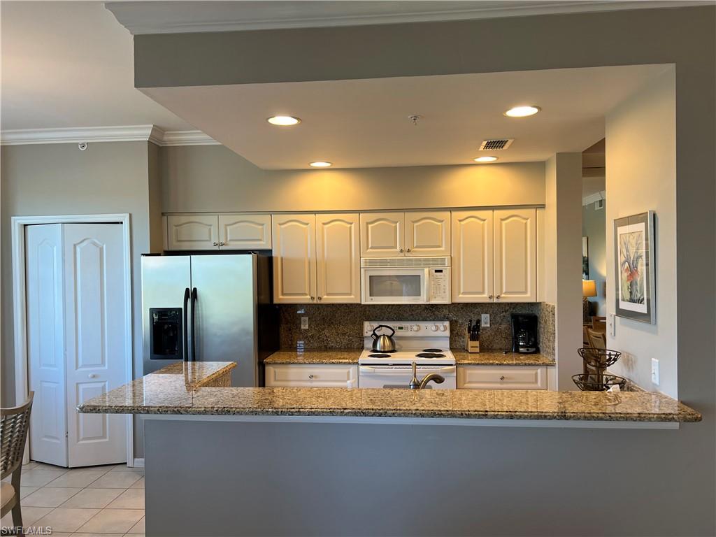 7625 Arbor Lake Court, Unit 332 Naples, FL 34112 - Photo 9 of 26 a kitchen with stainless steel appliances granite countertop a sink and a refrigerator