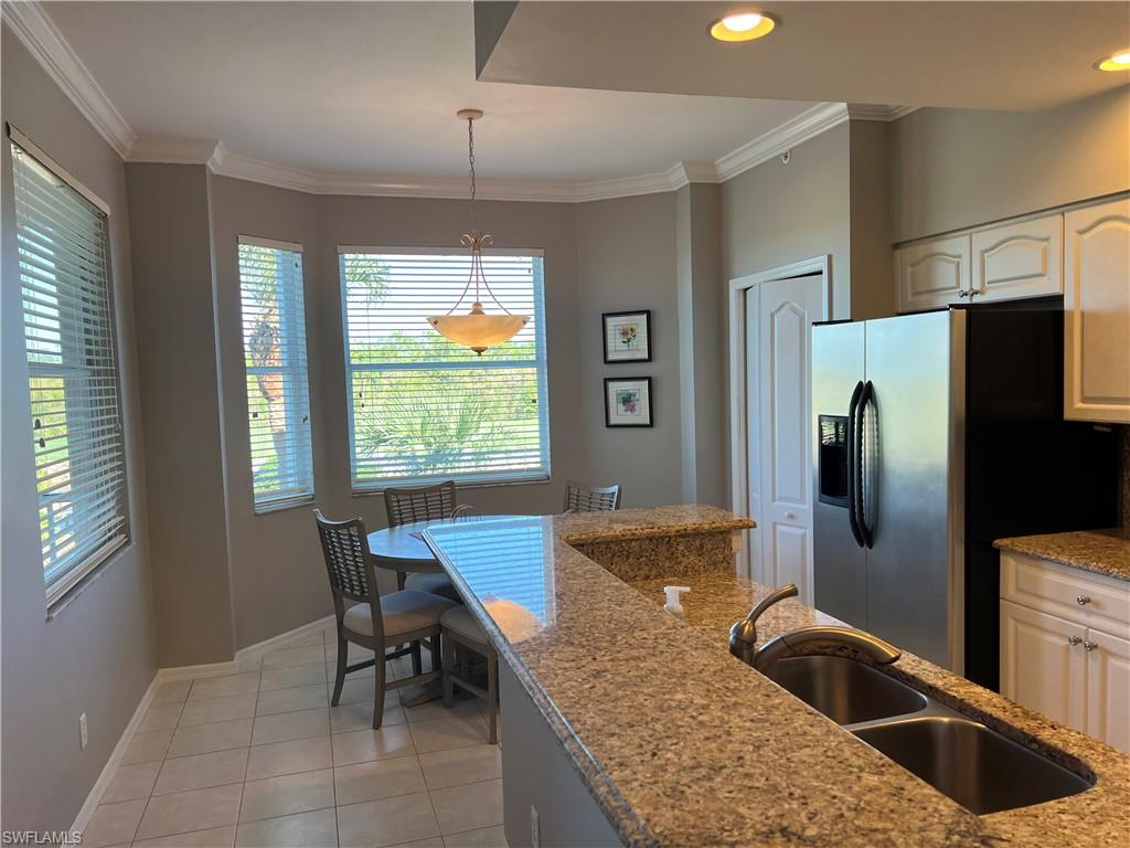 7625 Arbor Lake Court, Unit 332 Naples, FL 34112 - Photo 10 of 26 a kitchen with stainless steel appliances granite countertop sink refrigerator and window