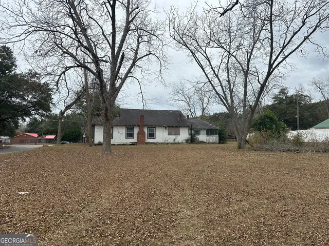a front view of a house with a yard and trees